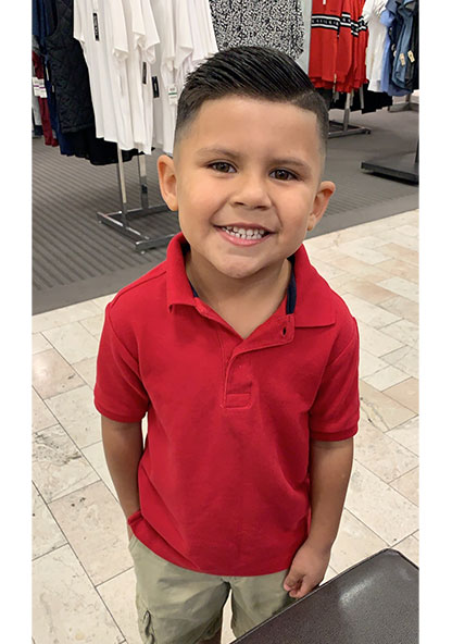 Young, 8-year-old boy Emmitt Gaza smiling at the camera