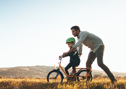 A father teaching his son how to ride a bike