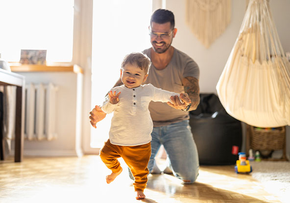 A father helping his son take his first steps